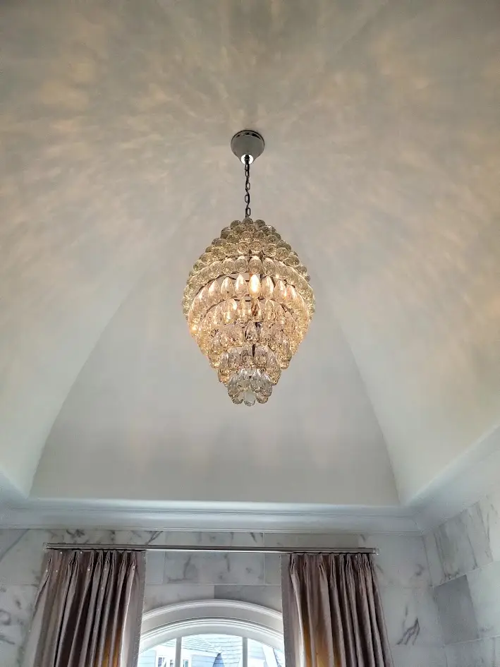 small crystal chandelier in large bathroom with high ceiling